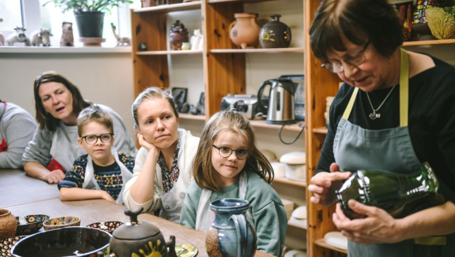 Keramikas rokdarbu meistardarbnīca/nodarbība - kadrā apmeklētāji un keramiķe