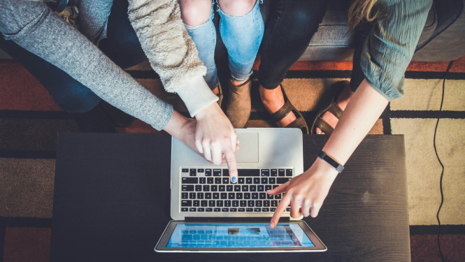 Trīs studējošie pie datora