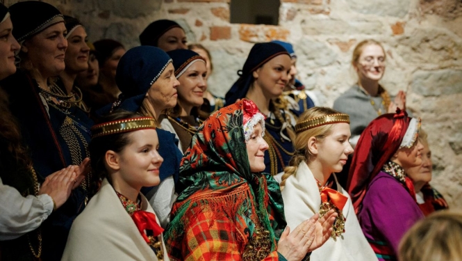 Folkloras kopu dalībnieki tautastērpos aplaudē