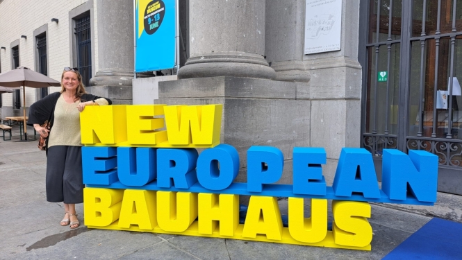 Arhitekte Ieva Pakalniņa pie dzelteni-zila krāsota uzraksta New European Bauhaus