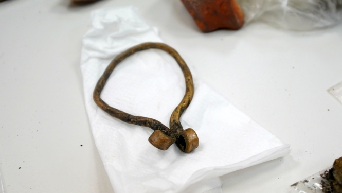 Uz balta galda, baltas plēves arheoloģiskais atradums - pakavsakta