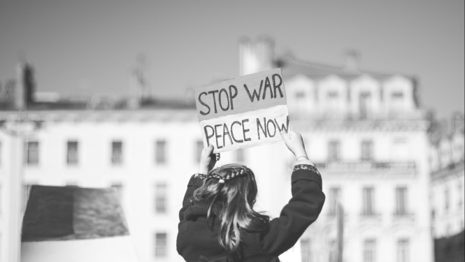 Sieviete tur rokās kartona planšeti ar uzrakstu: Stop war, peace now