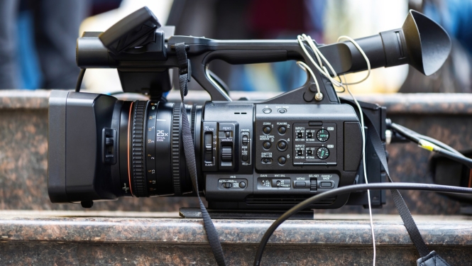 Tuvplānā profesionāla videokamera novietota uz akmens kāpņu virsmas