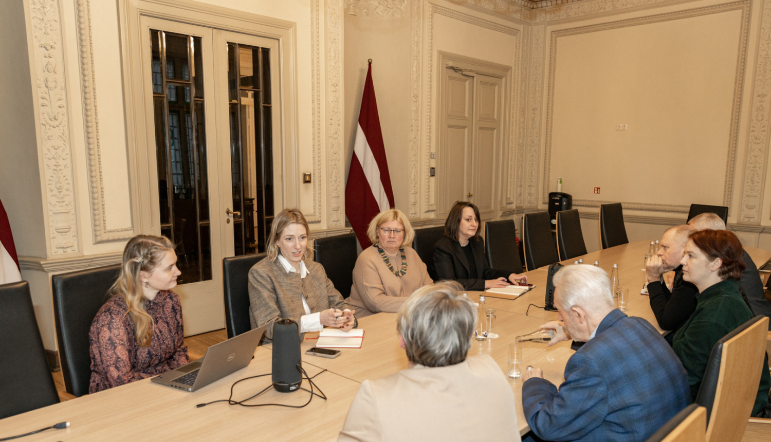Astoņi cilvēki pie sanāksmju galda