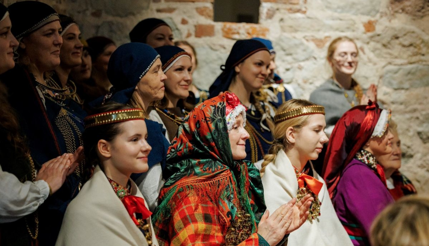 Folkloras kopu dalībnieki tautastērpos aplaudē