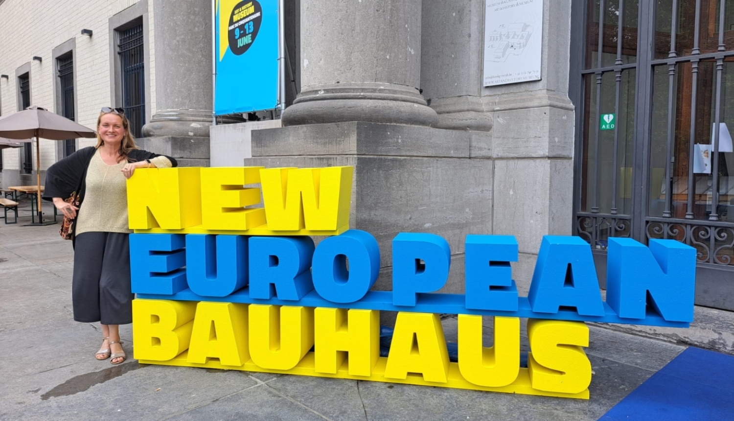 Arhitekte Ieva Pakalniņa pie dzelteni-zila krāsota uzraksta New European Bauhaus