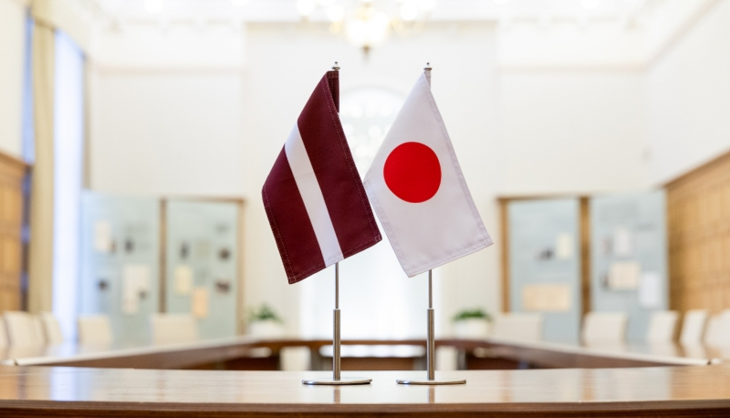 Latvijas karogs un Japānas karogs sanāksmju telpā uz galda
