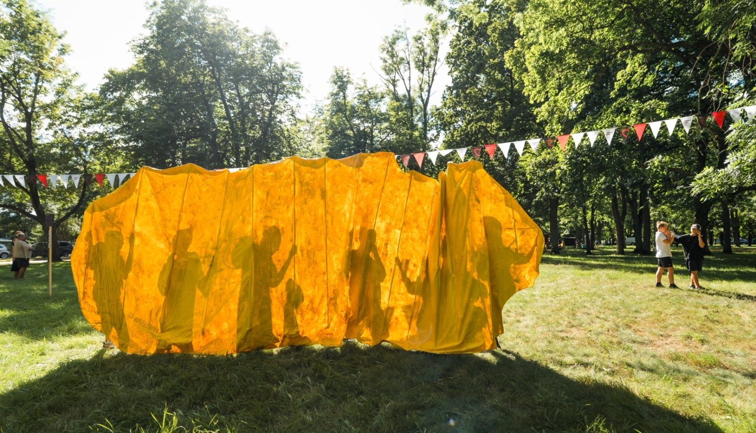 Parkā cilvēku ēnas uz dzeltena tekstila