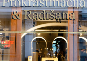Ieeja muzejā; uzraksts Ekspozīcija Prokrastinācija & radīšana