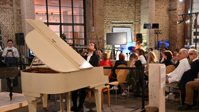 Pianists Aleksandrs Osokins pie flīģeļa klausītāju pilnā zālē