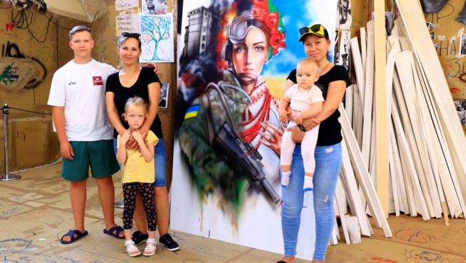 Māksliniece ar bērniem pie gleznas