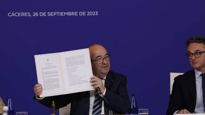 Divi vīrieši pie galda preses konferencē