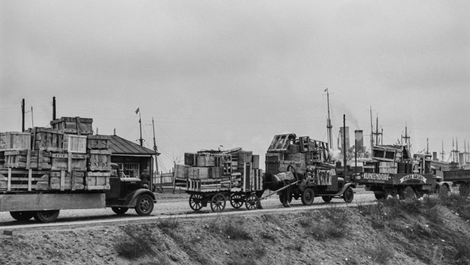 Melnbalts attēls ar kravas mašīnu rindu uz dambja