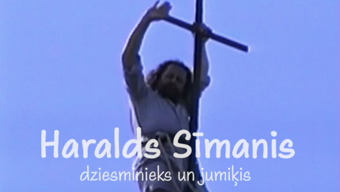 Filmas kadrs ar mūziķi Haraldu Sīmani un koka krustu. Teksts: Haralds Sīmanis, dziesminieks un jumiķis