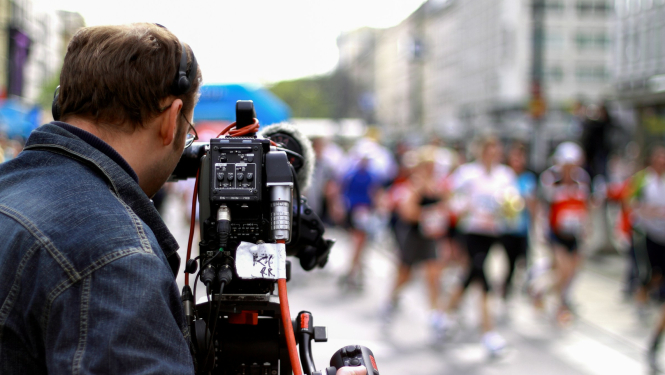 TV kameras operators filmējot publisku pasākumu pilsētvidē