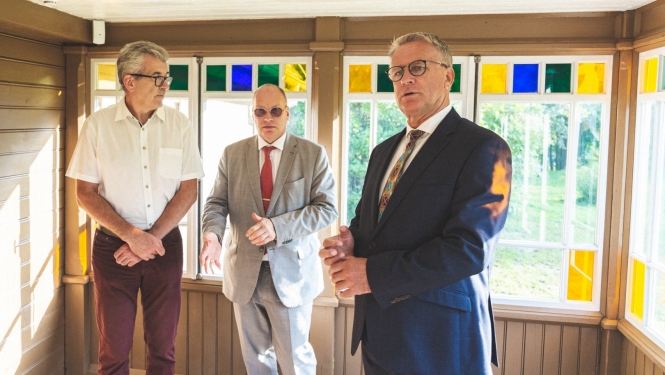 Trīs cilvēki muzeja telpās