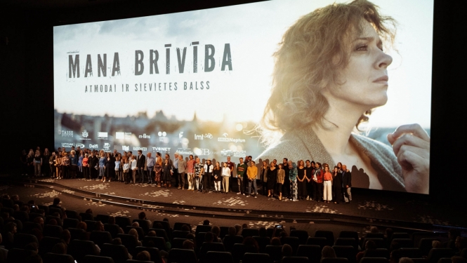 Cilvēku grupa uz skatuves filmas pirmizrādē
