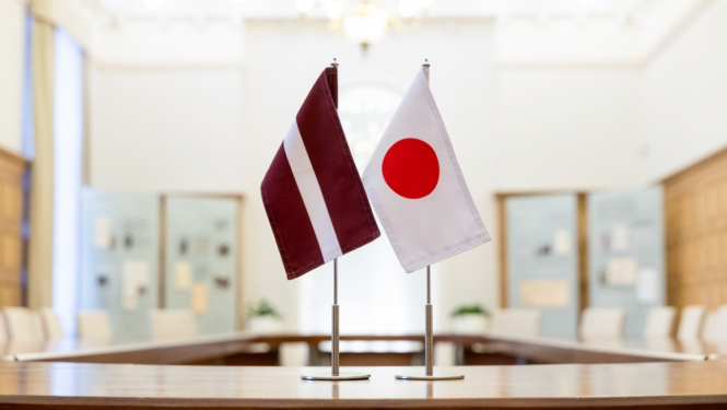 Latvijas karogs un Japānas karogs sanāksmju telpā uz galda
