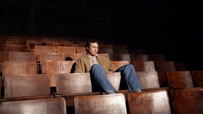 Aktieris skatītāju zālē uz krēsliem