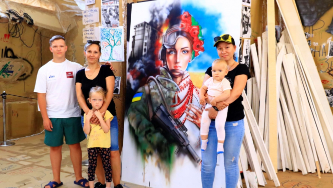 Māksliniece ar bērniem pie gleznas