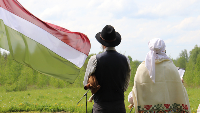 Divi cilvēki Sēlijas tautas tērpos un Sēlijas karogs