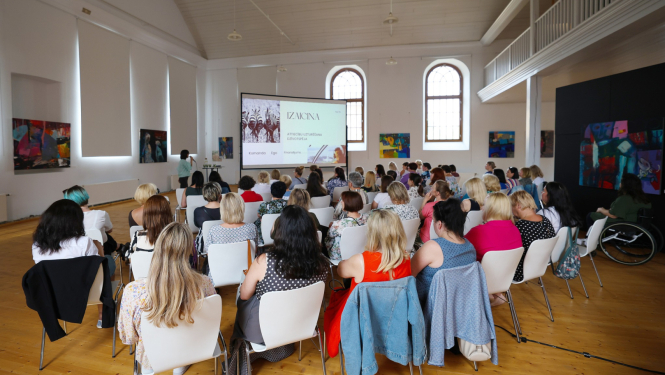 Semināra dalībnieki sēž un klausās prezentāciju 