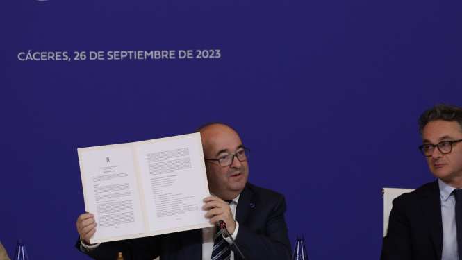 Divi vīrieši pie galda preses konferencē