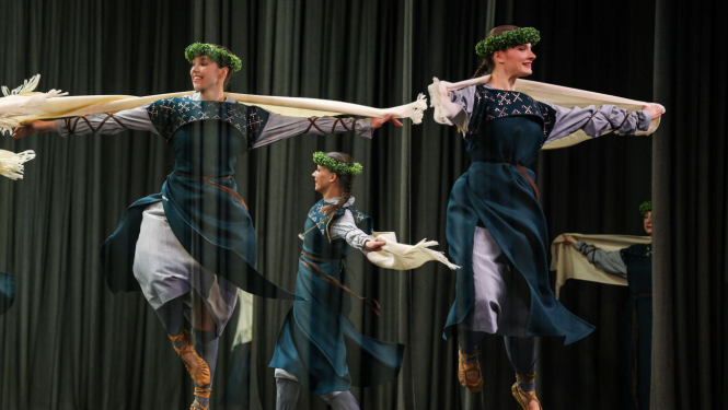 Tautas deju kolektīva dejotāji uz skatuves