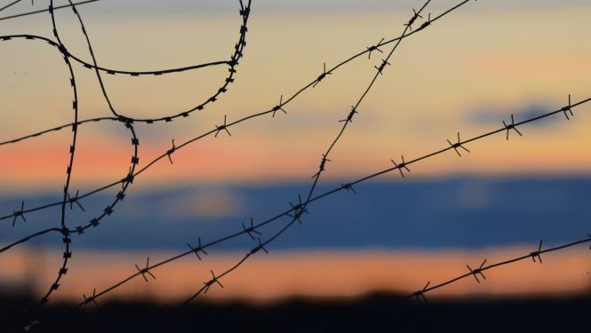 Nostieptas dzeloņdrātis un vakara debesis
