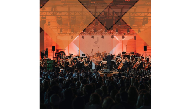 Pasākums Dzintaru koncertzālē, uz skatuves simfoniskais orķestris.