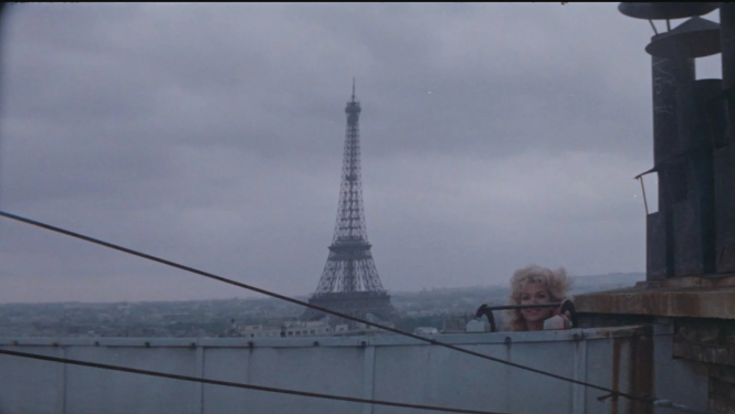 “Parīzes manekeni” kadra daļa. Skats uz Parīzi, Eifeļa torni un sievieti no jumta.