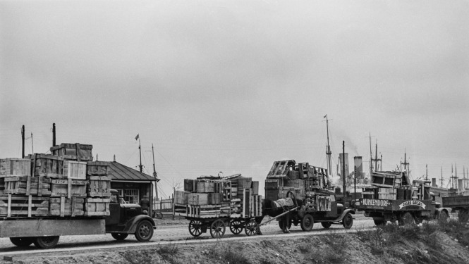 Melnbalts attēls ar kravas mašīnu rindu uz dambja