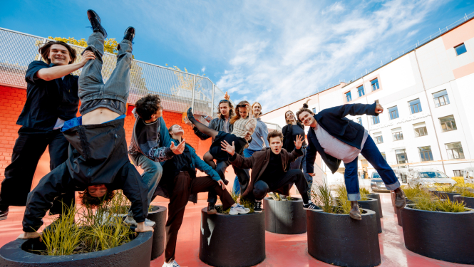 Latvijas Kultūras akadēmijas studentu grupa pozē košā iekšpagalmā