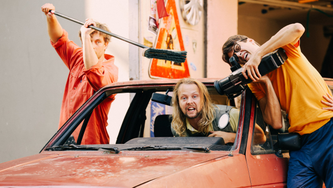 Izrāde "Pagalms atdzīvojas" un trīs izrādes aktieri ar auto, kameru un slotu