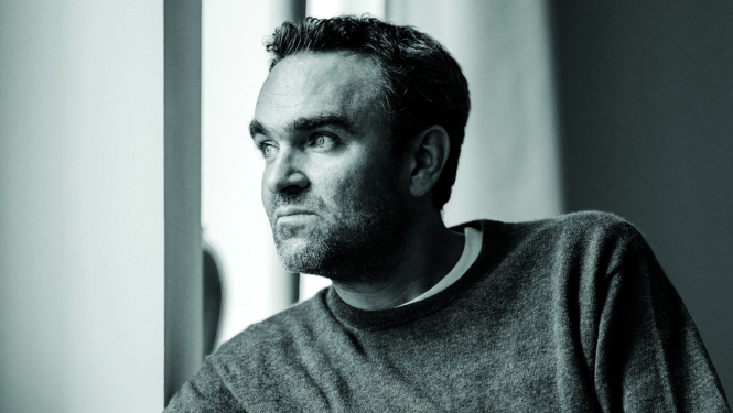 Mūziķis Jērgs Vidmans pozē telpā pie loga