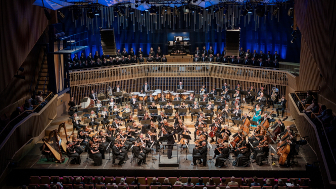 Koncerts koncertzālē "Latvija". Uz skatuves simfoniskais orķestris, sēdvietās - skatītāji