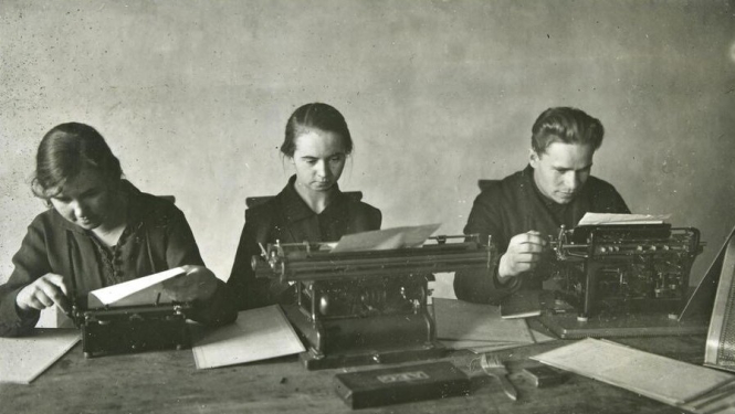 Trīs arhīva darbinieki pie rakstāmmašīnām
