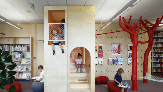 Bērni skatās un lasa grāmatas Latvijas Nacionālās bibliotēkas lasītavā