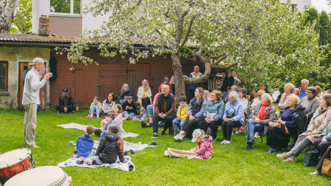 Cilvēku grupa kopienas programmas pasākumā plašā pagalmā