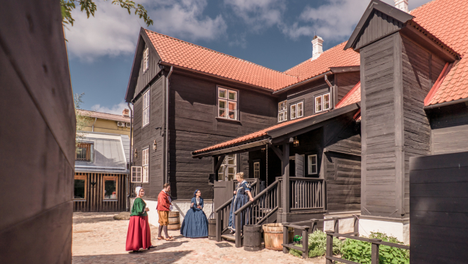 Liepājas Hoijeres nama pagalms ar vēsturiskos kostīmos ģērbtām darbiniecēm