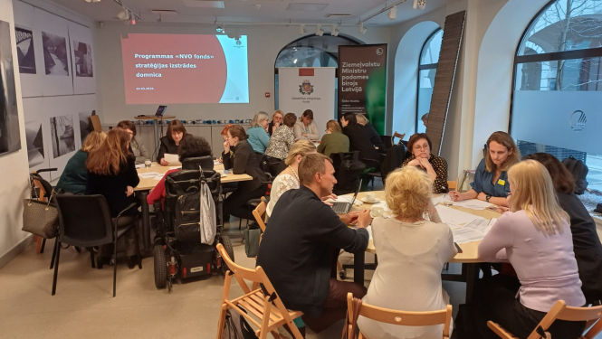 Domnīcas dalībnieki pie galdiem