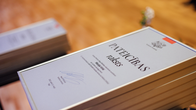 KM pateicības raksti uz galda