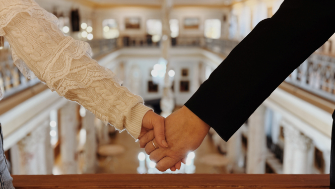 Divi cilvēki sadevušies rokās muzeja telpās