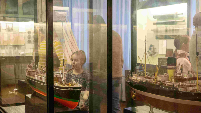 Skolēni muzejā pie vitrīnām