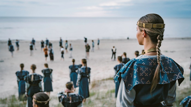 Deju kolektīva dalībnieki tautas tērpos jūras krastā