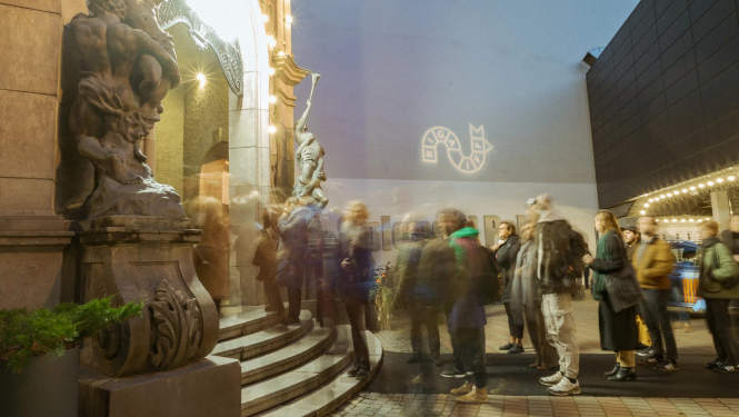 Apmeklētāji pie kino teātra ieejas