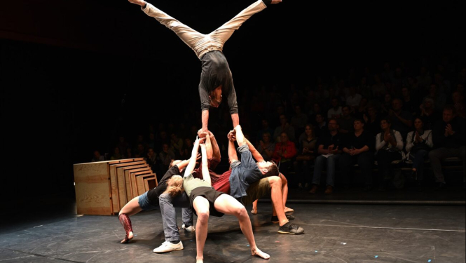 Cirka mākslinieku trupa uzstājas arēnā ar žonglēšanas priekšnesumu