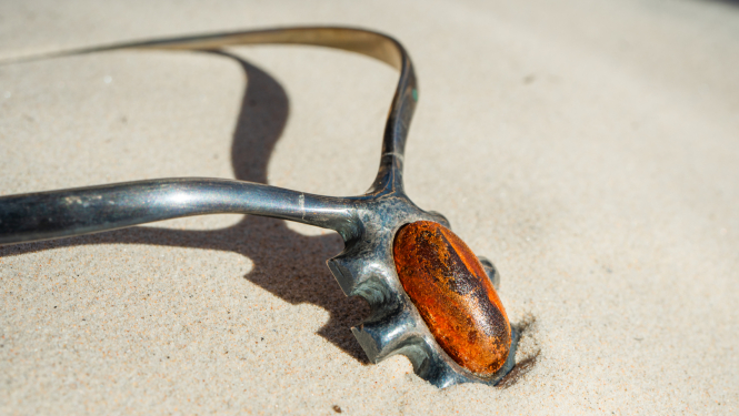 Darbs no izstādes - metāla rota ar krāsainu akmens elementu