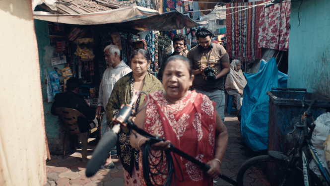 Kadrs no filmas “Sarkano lukturu cerību zvaigznes” ar Kaligatas sarkano lukturu ielu un cilvēkiem