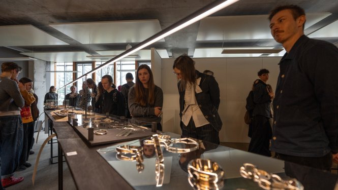 Izstādes apmeklētāji aplūko izstādes darbus